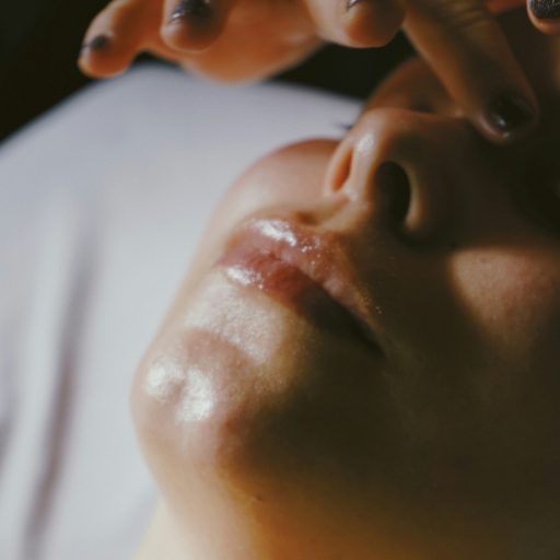 A dreamy image of a facial massage. A close up of a woman's face with hands about to touch her head.